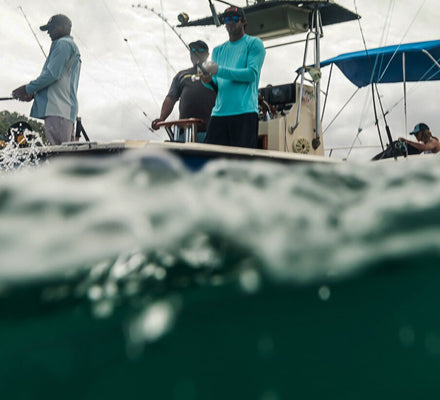 Men fishing from a boat in blue green water